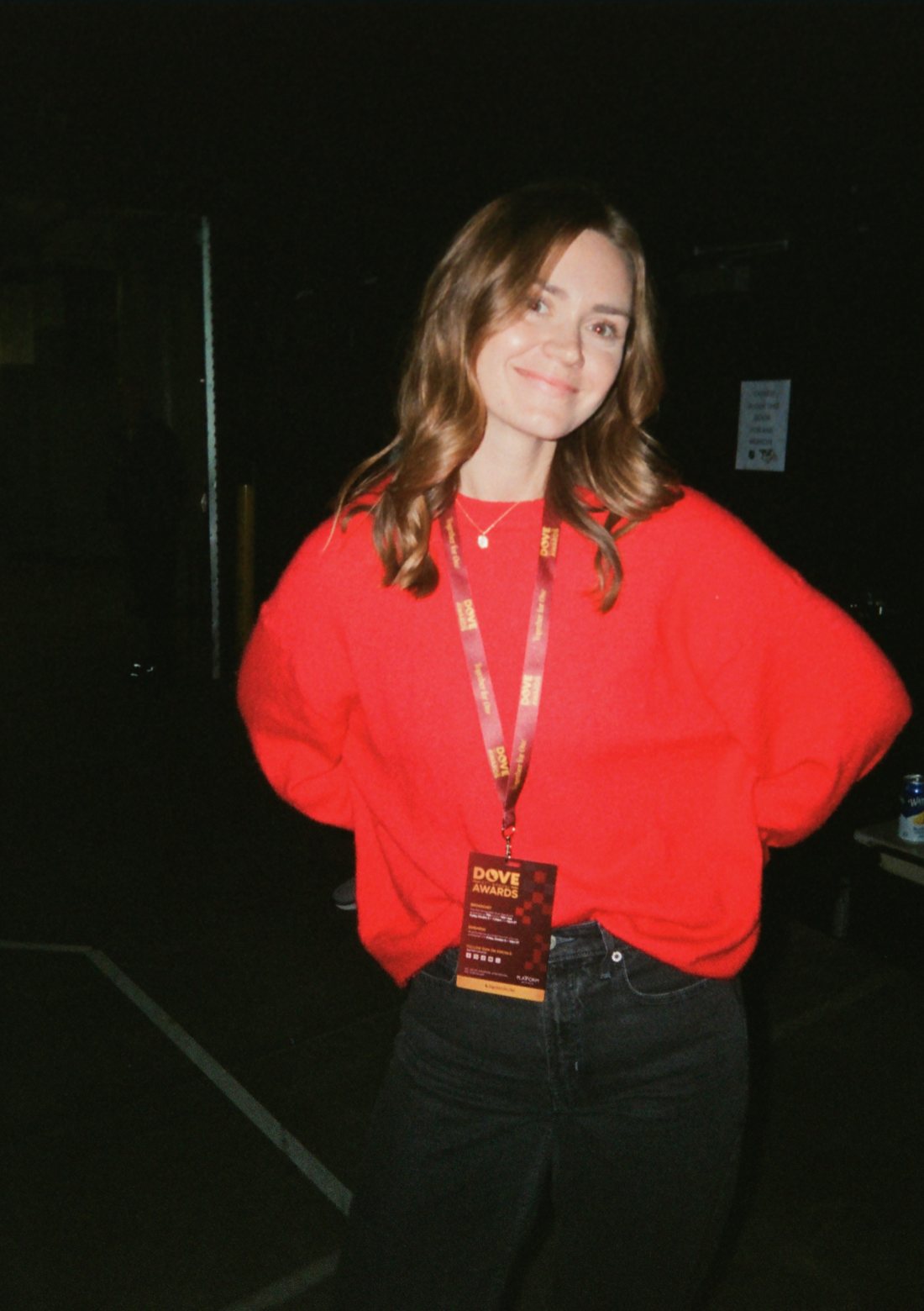 Sidney in a red sweater wearing a Dove Awards credential backstage